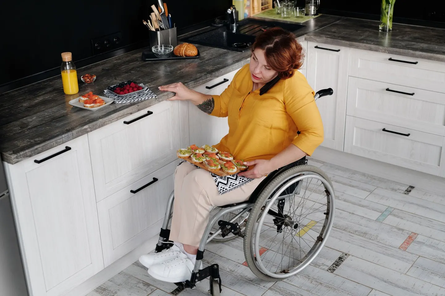 Woman using a wheelchair at a kitchen counter with breakfast laid out
