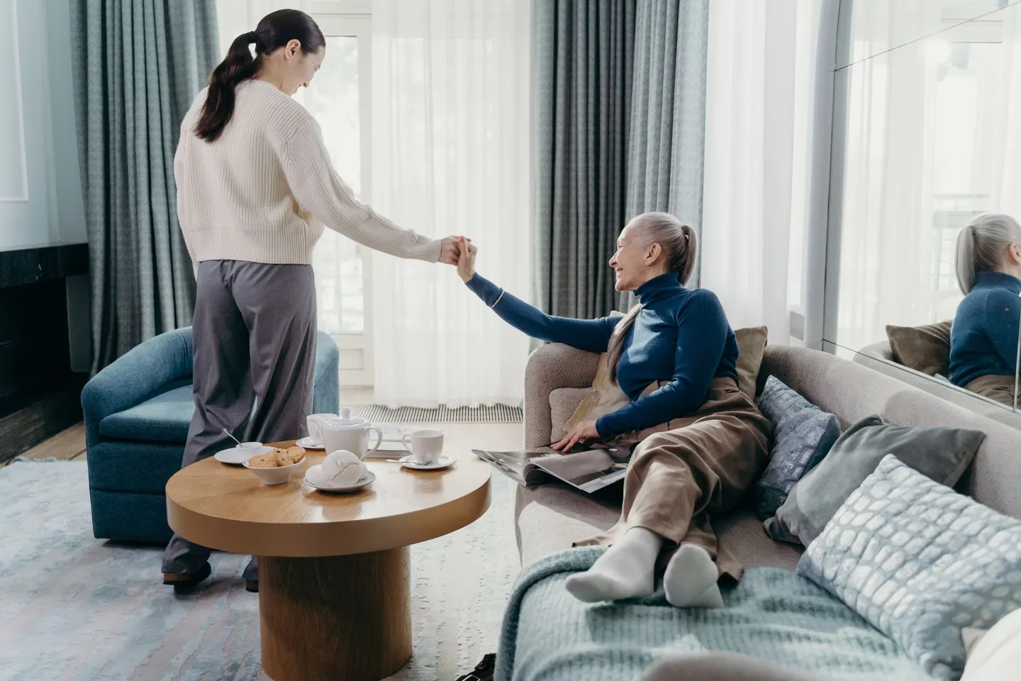 An older woman and her adult daughter relaxing together at home
