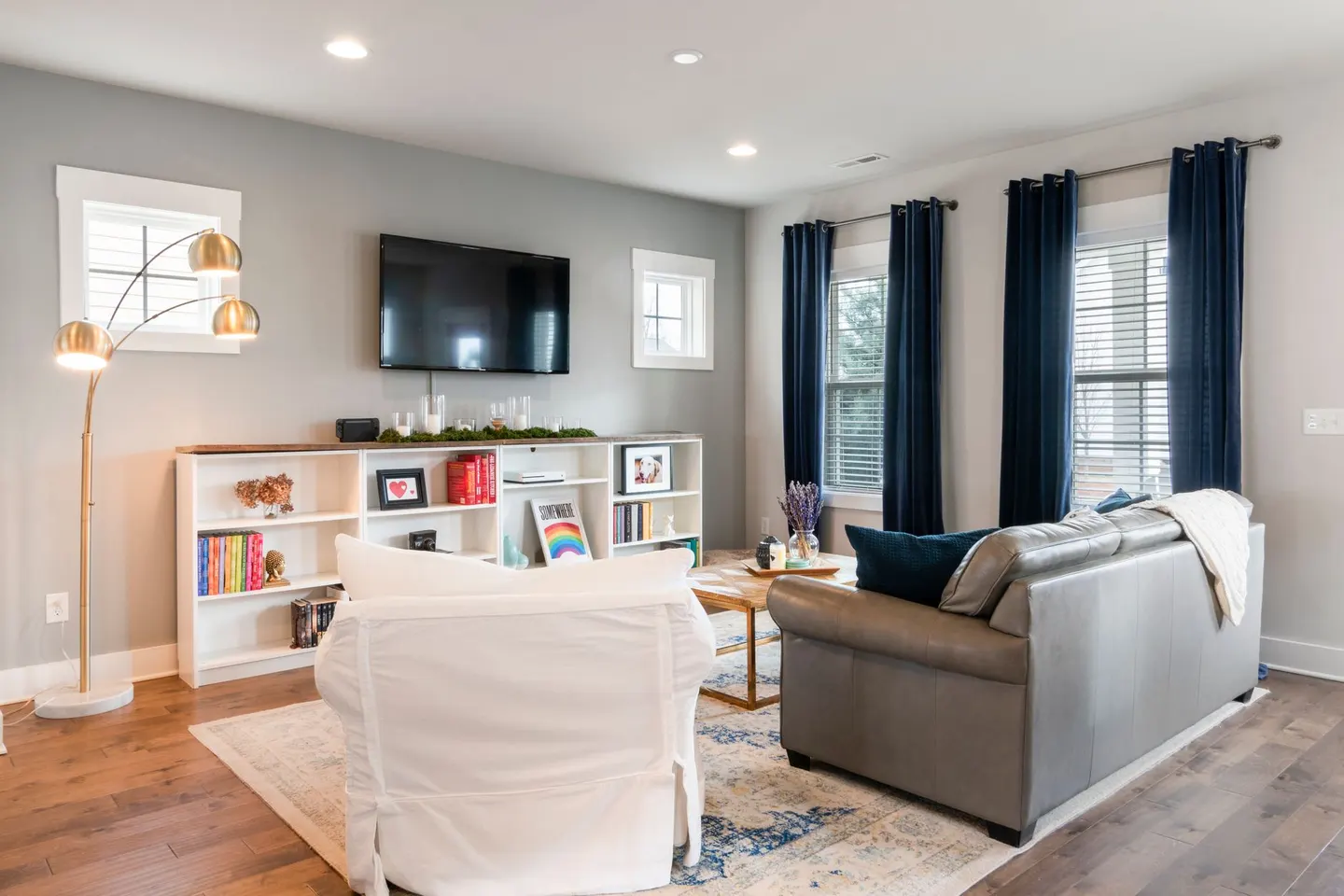 A bright living room with a floor lamp and large windows