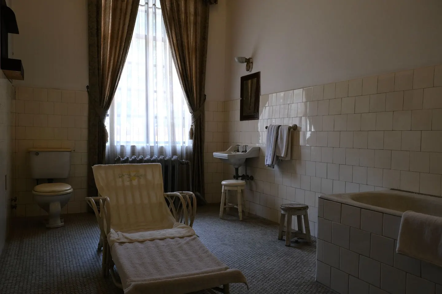 Dated bathroom with a tub, wall tile and a window