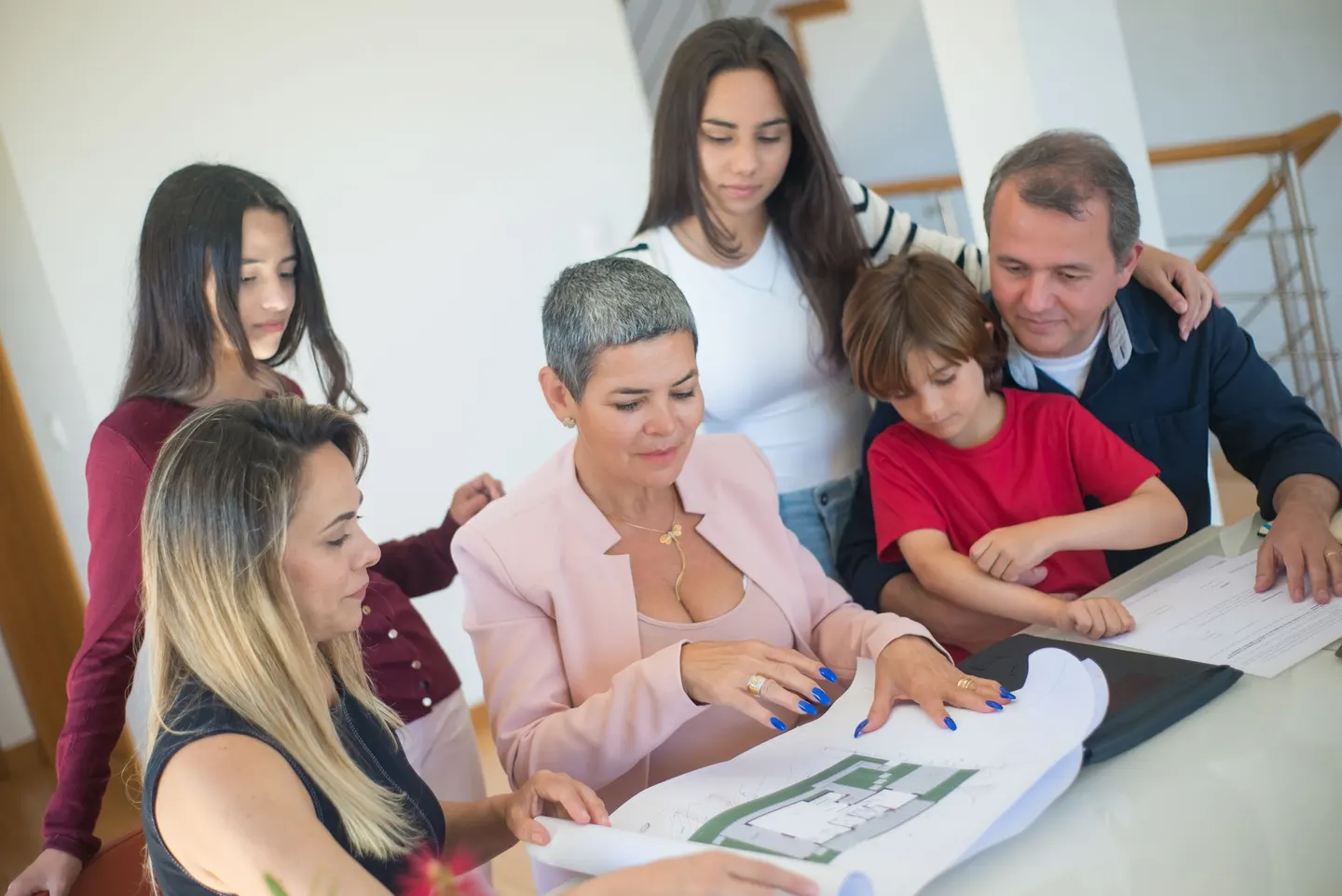 Family reviewing a floor plan at a table