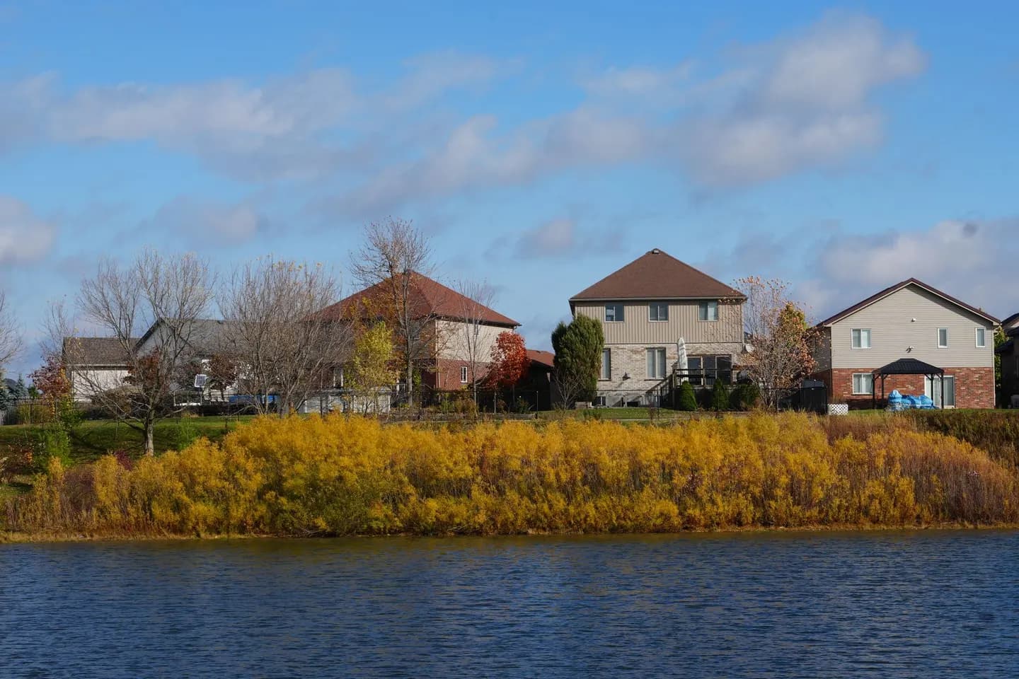 Suburban homes beside a lake in autumn