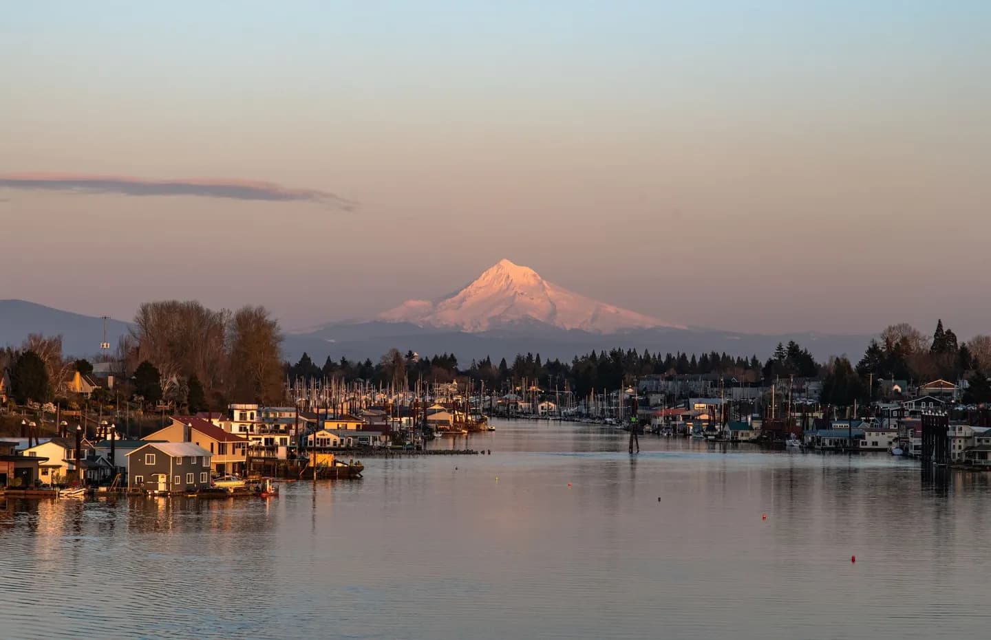 Mount Hood at sunset above a marina and lakeside homes