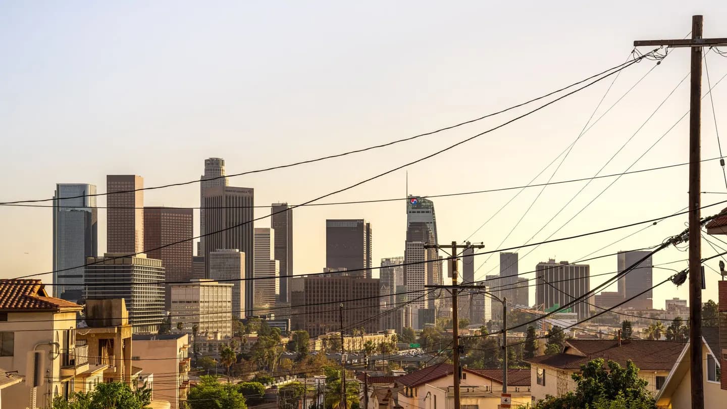 The downtown Los Angeles skyline at sunset, seen from a residential hillside