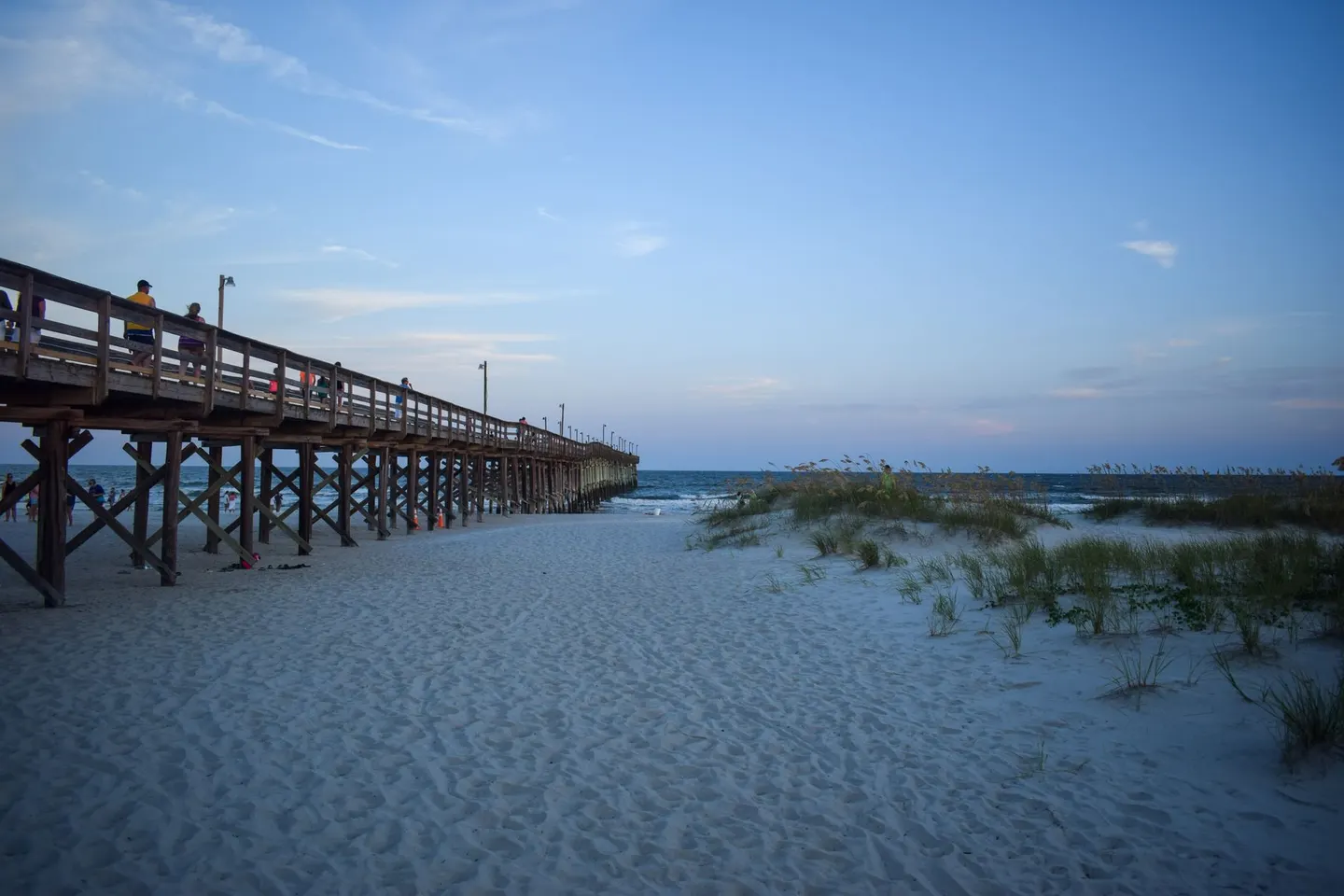 A wooden pier reaching into the Atlantic at dusk
