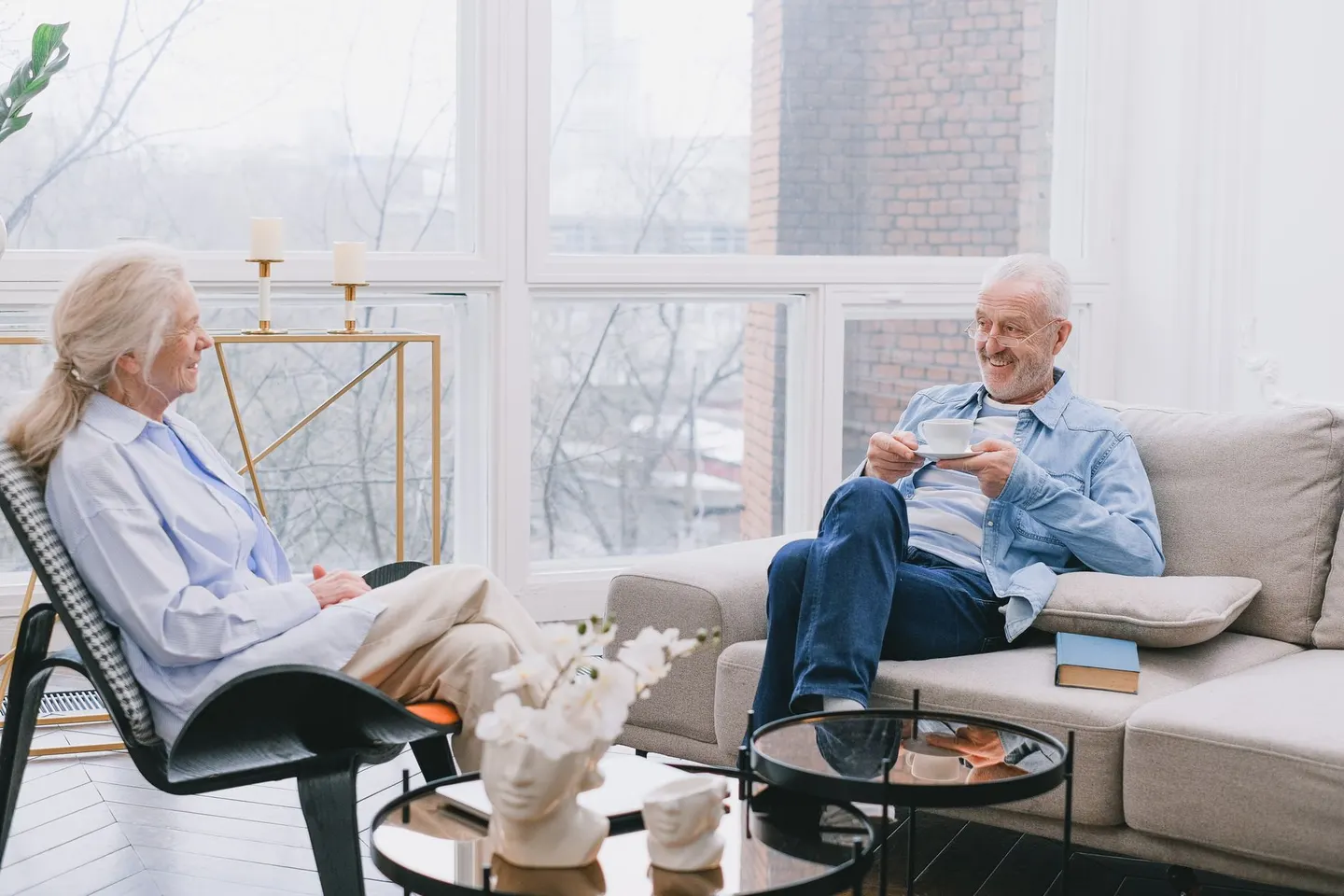 An older couple talking over tea in their living room