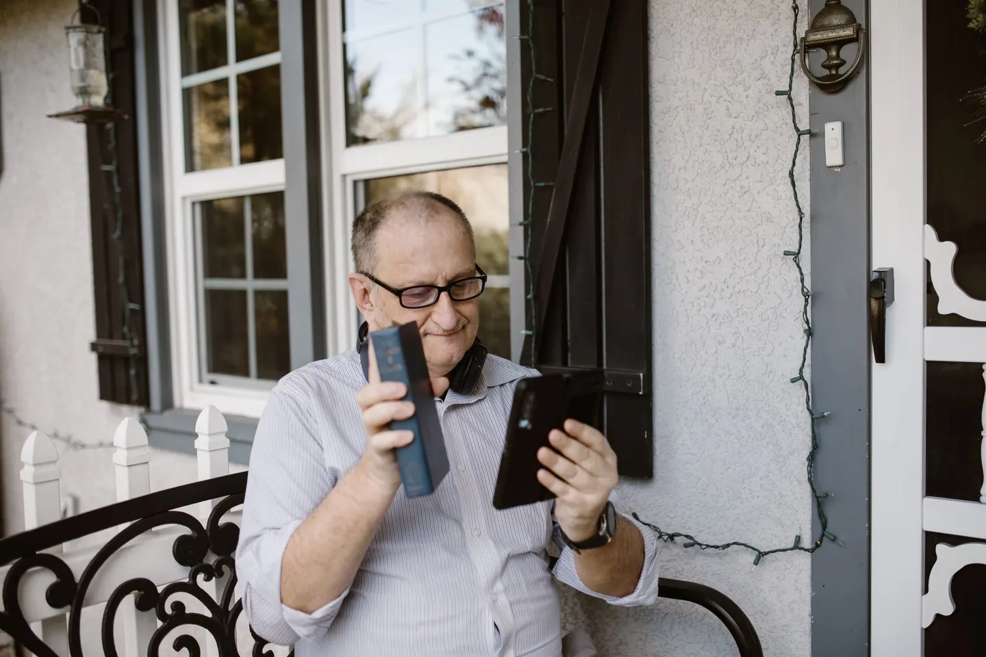 Older man on his porch looking at his phone