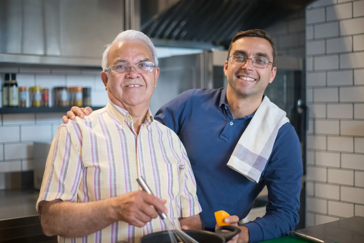 A father and son enjoy bonding time while cooking in a modern kitchen