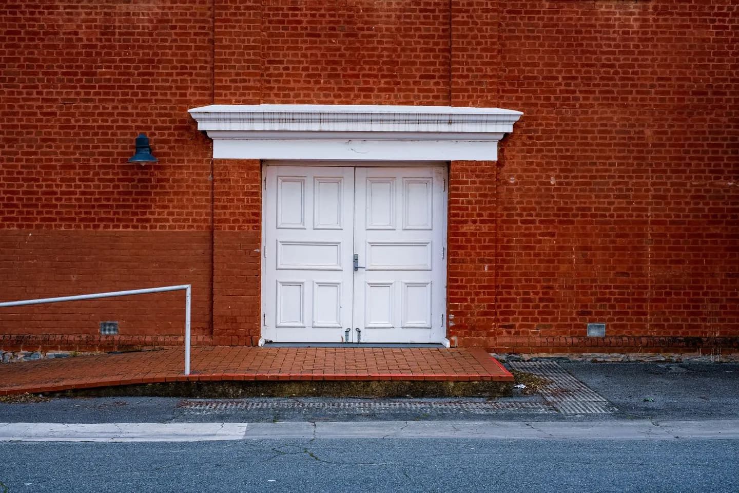 Brick entrance with a sloped ramp and a handrail