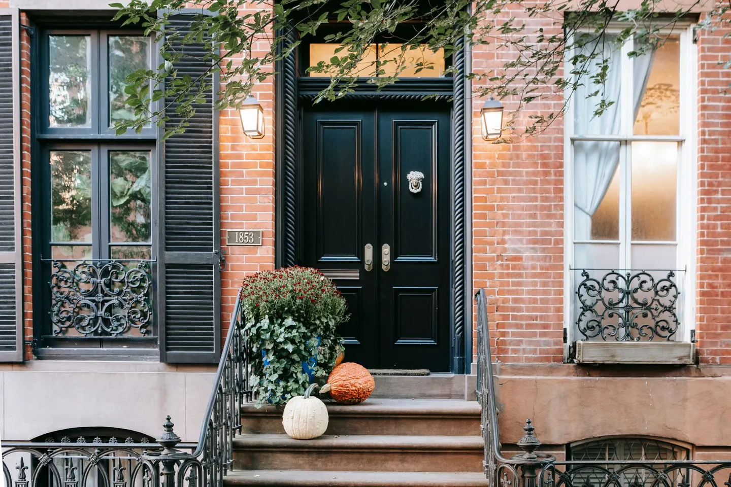 Brick rowhouse entrance with a railed stoop